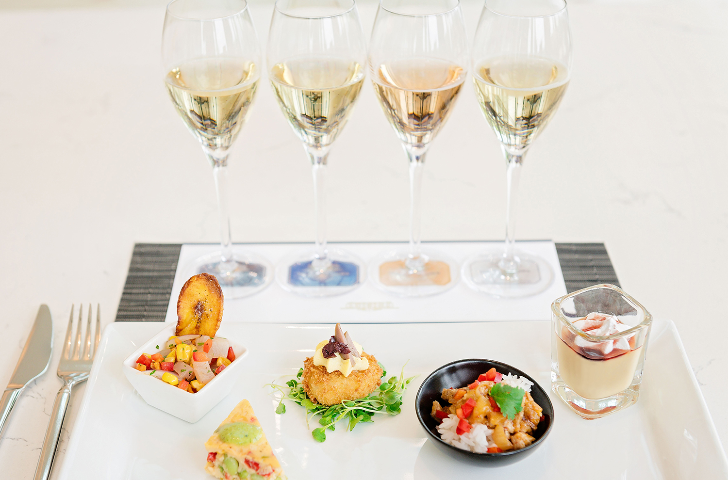 four sparkling flutes and a plate of five bites